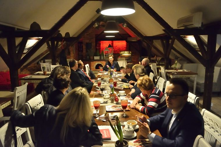 Uczestnicy spotkania klubu Rotary Warszawa-Belweder przy stole, marzec 2018