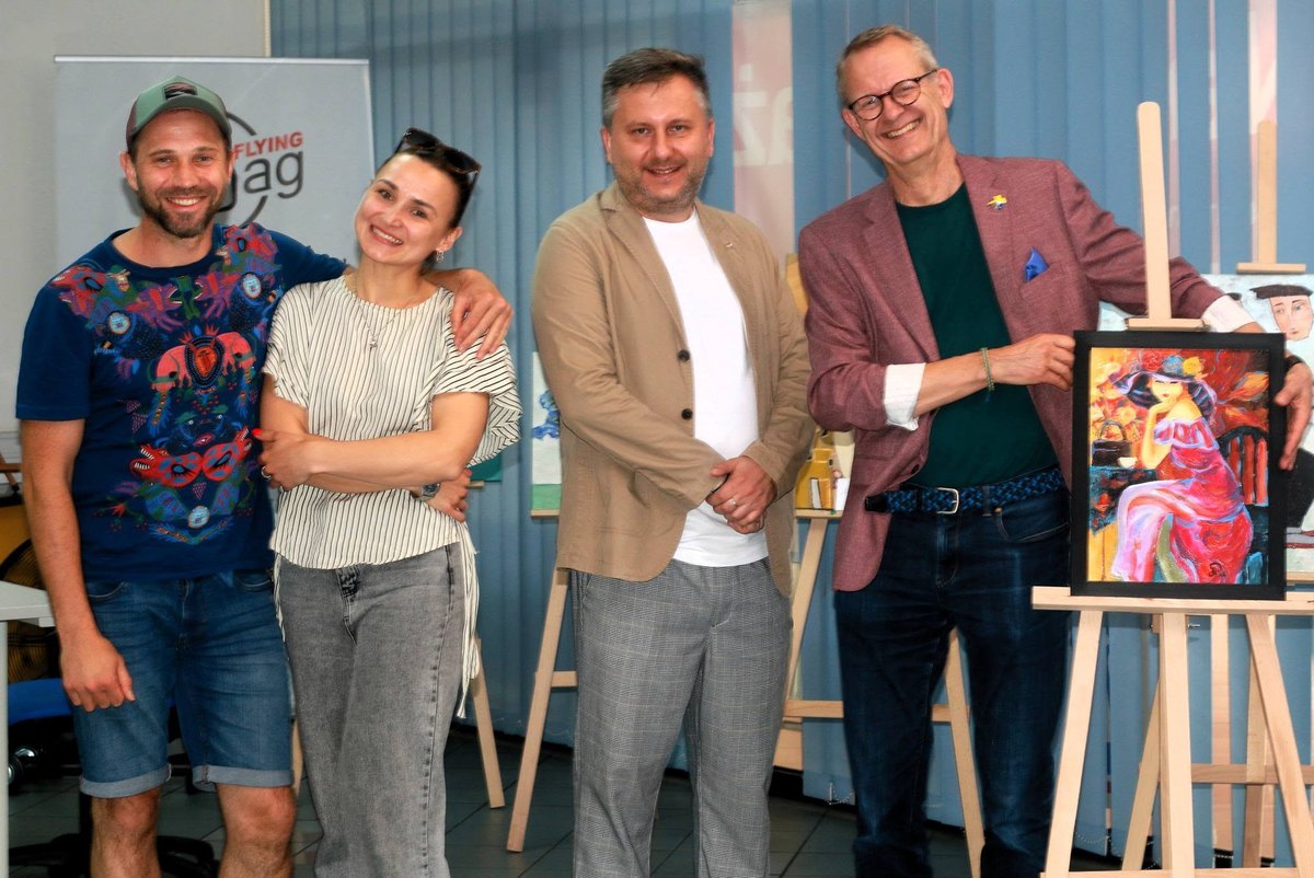 Czworo uczestników spotkania przy sztalugach z obrazami; po prawej Peter Zinck trzyma oprawiony obraz