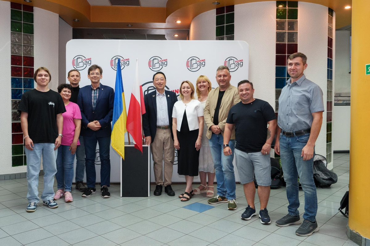 Wspólne zdjęcie uczestników spotkania przy flagach Ukrainy i Polski; pośrodku Kato Takehiko