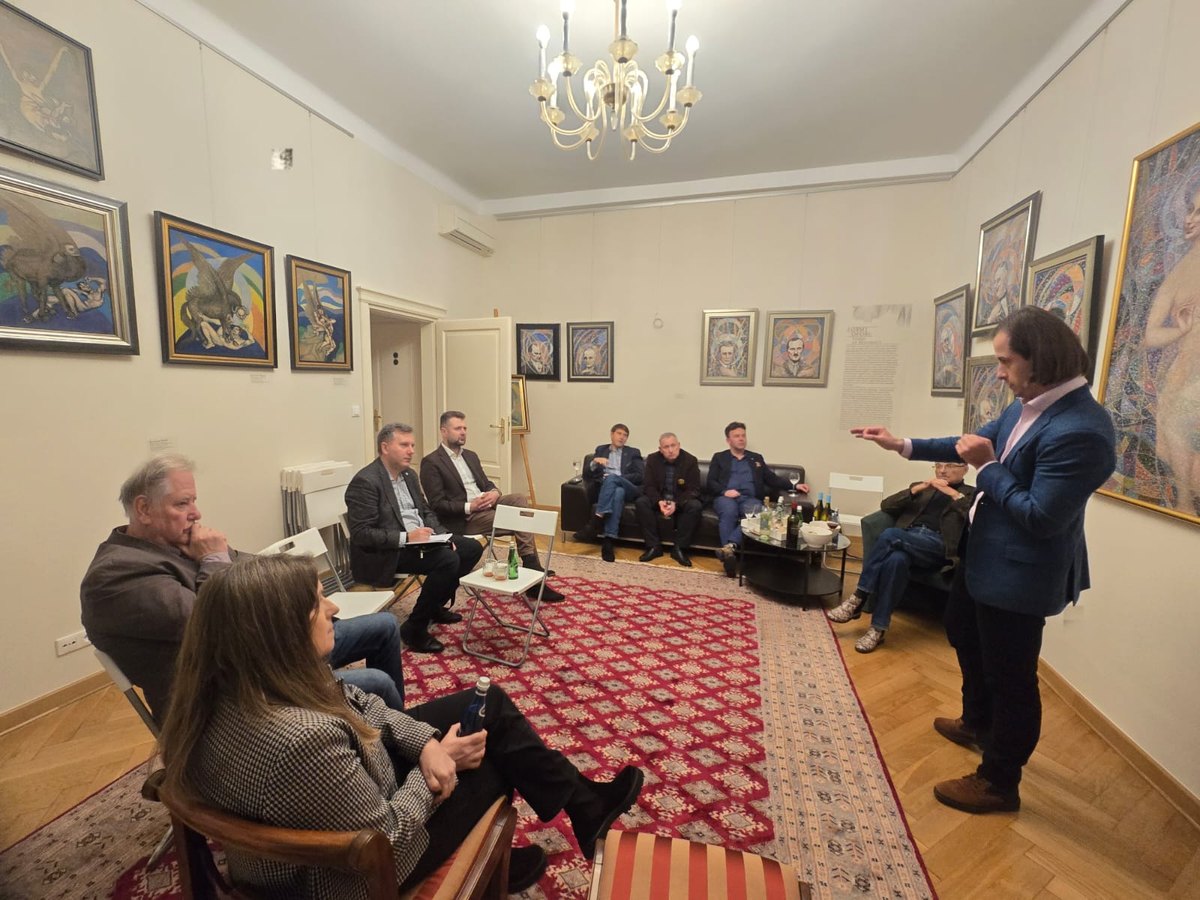 Uczestnicy uroczystości charterowej; jeden z rotarian trzyma proporczyk Rotary, inny czyta z kartki